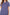 Woman wearing a blue patterned pajama top with white trim on a plain background