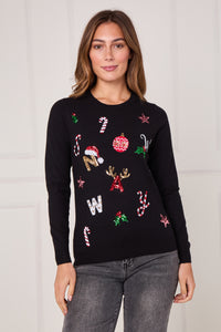 Woman wearing a black sweater with festive designs against a white background