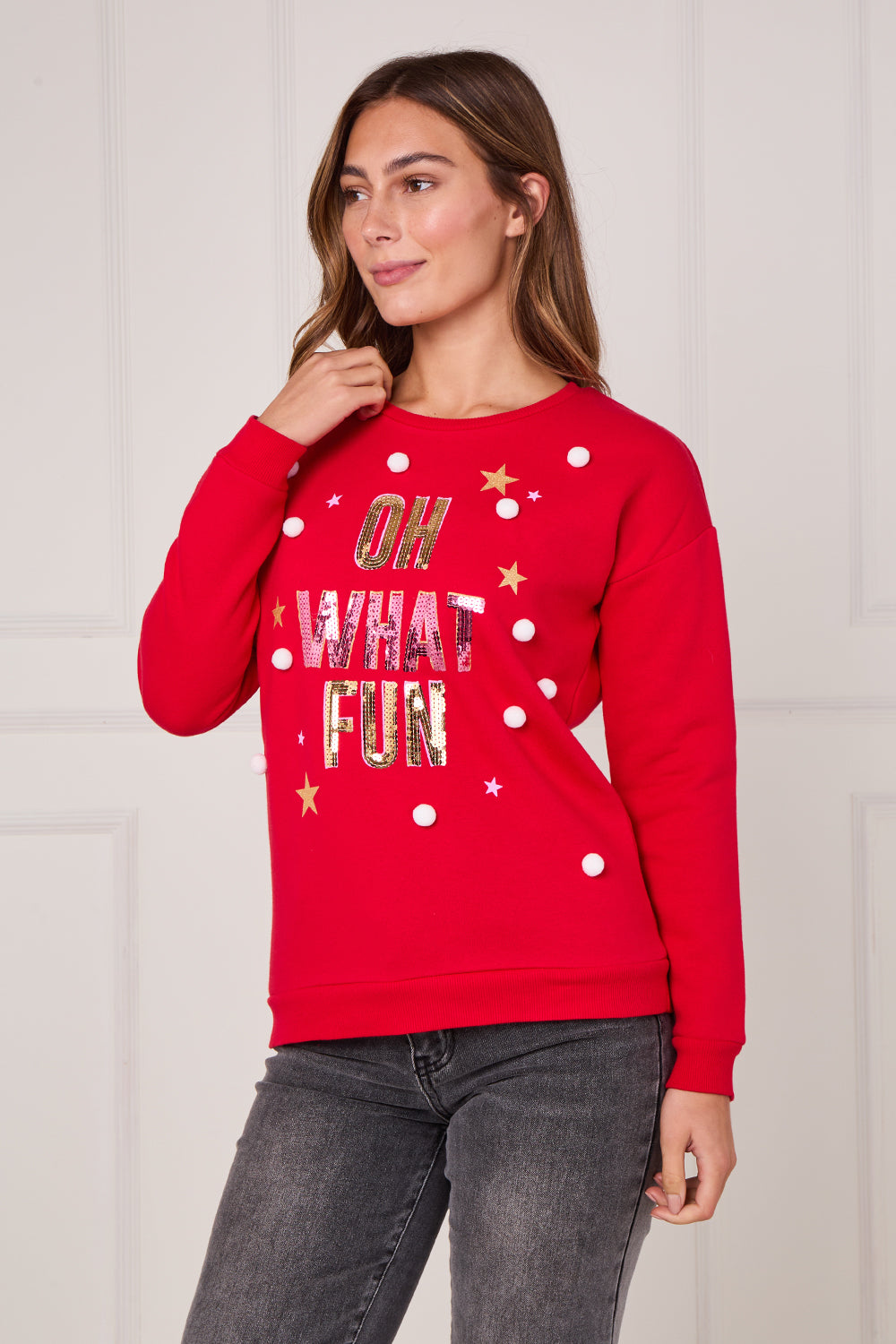 Woman wearing a red sweater with text and polka dots on a light background