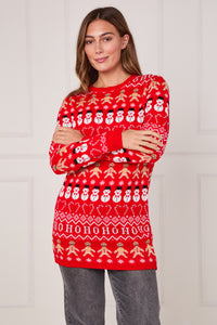 Woman wearing a red Christmas sweater with gingerbread men and snowmen pattern against a white background