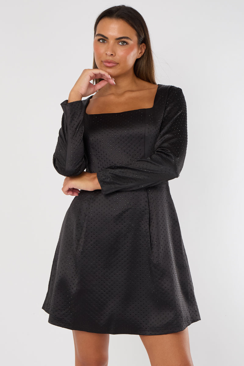 Woman wearing a black dress with long sleeves on a white background