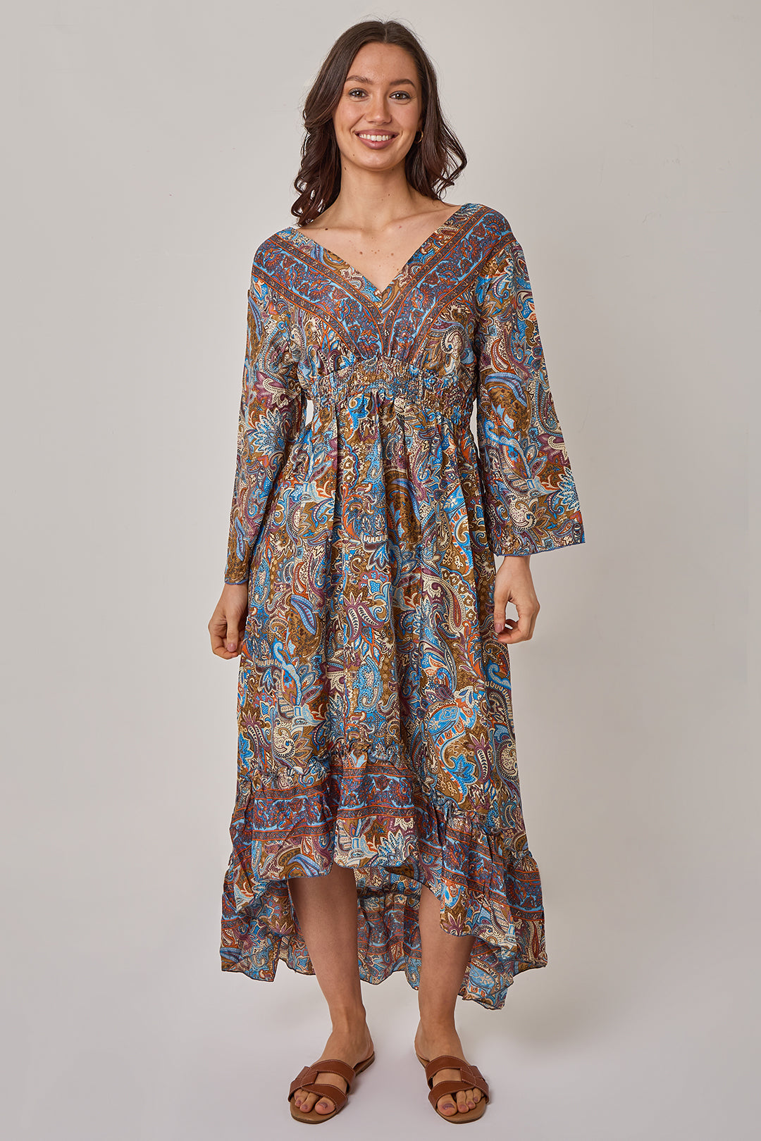 Woman wearing a patterned dress on a plain background
