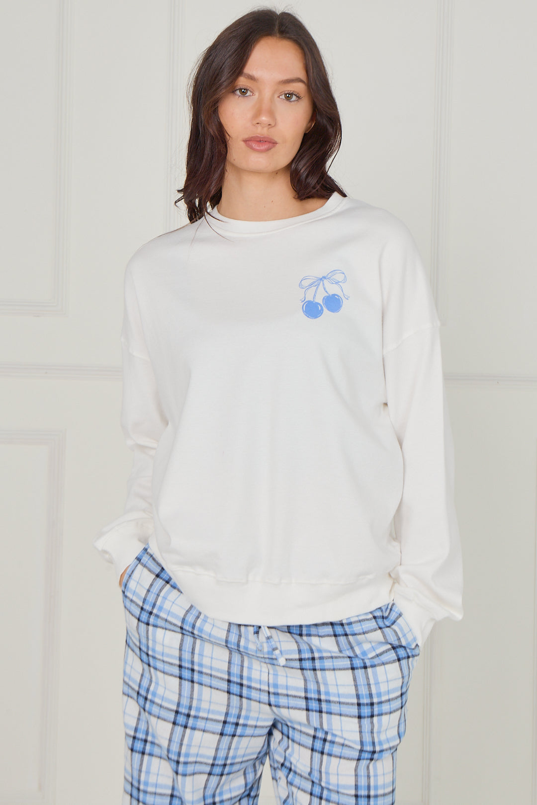 Women’s 100% cotton pyjama set in white and blue check, showing front view with small blue cherry logo on sweatshirt.