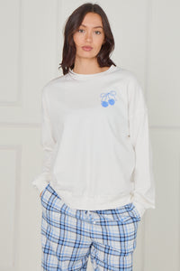 Women’s 100% cotton pyjama set in white and blue check, showing front view with small blue cherry logo on sweatshirt.