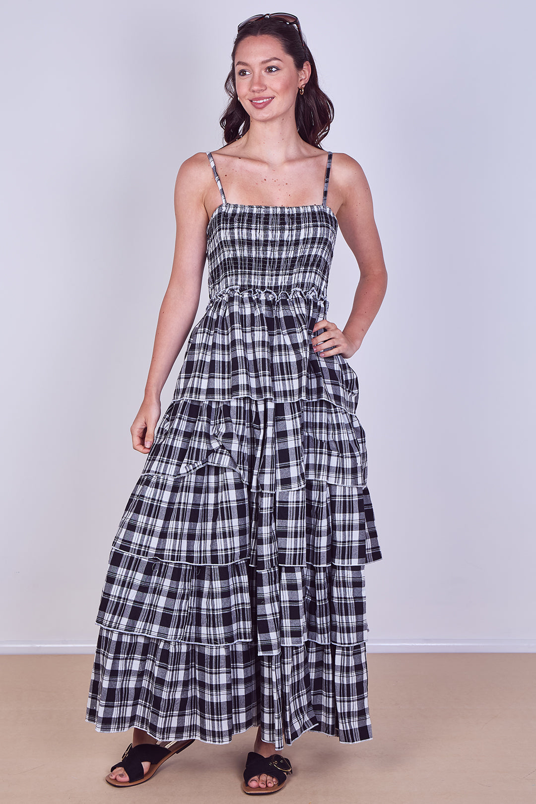 Woman wearing a black and white plaid dress against a plain background