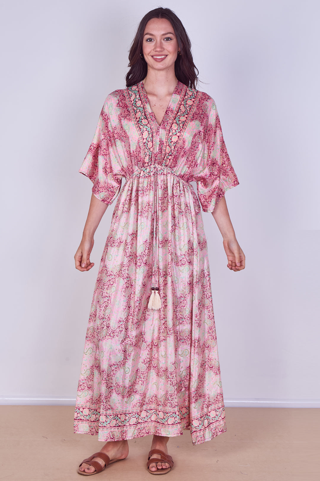 Woman wearing a pink floral dress against a white background