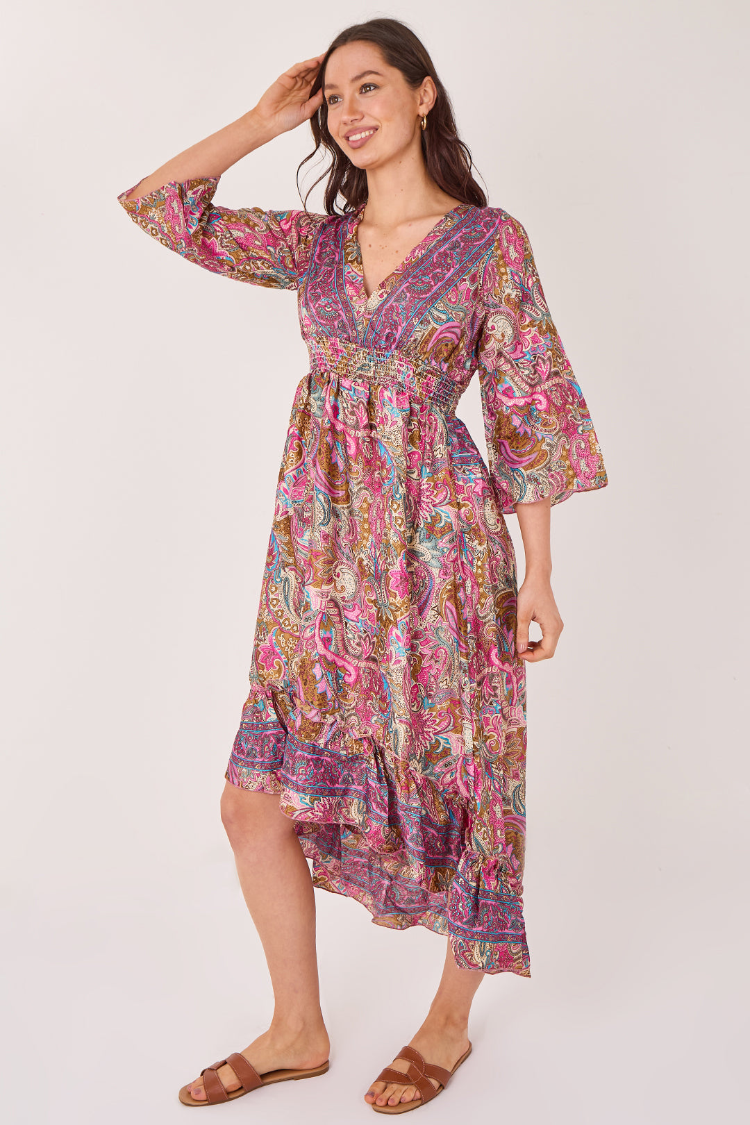 Woman wearing a colorful patterned dress on a white background