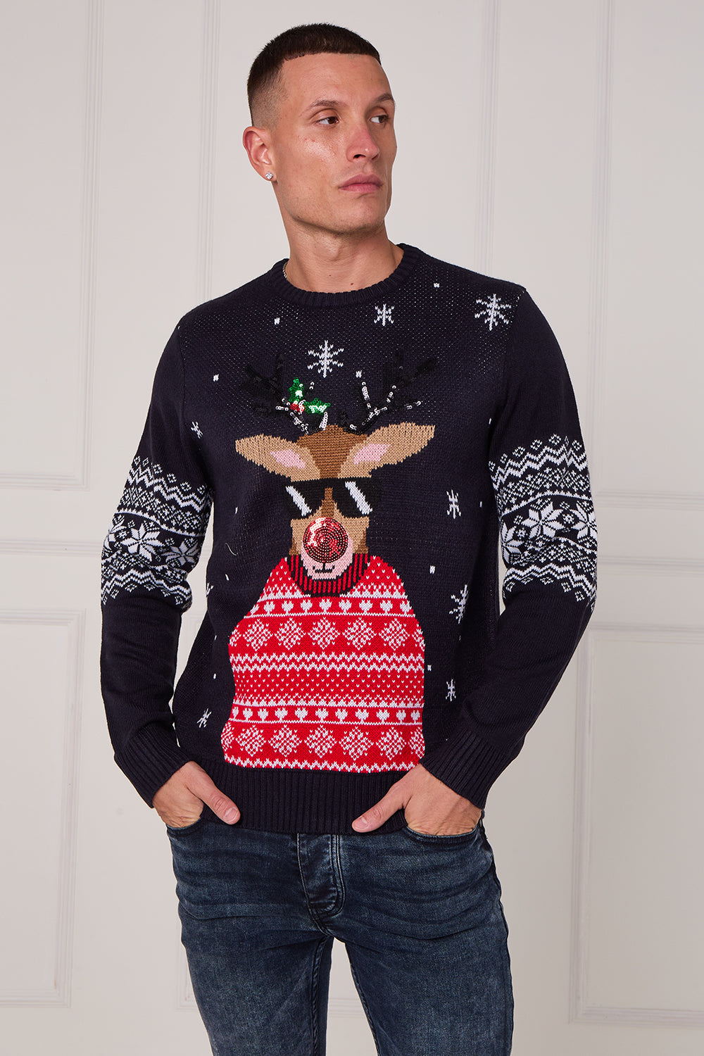 Man wearing a festive sweater with a reindeer design against a white background