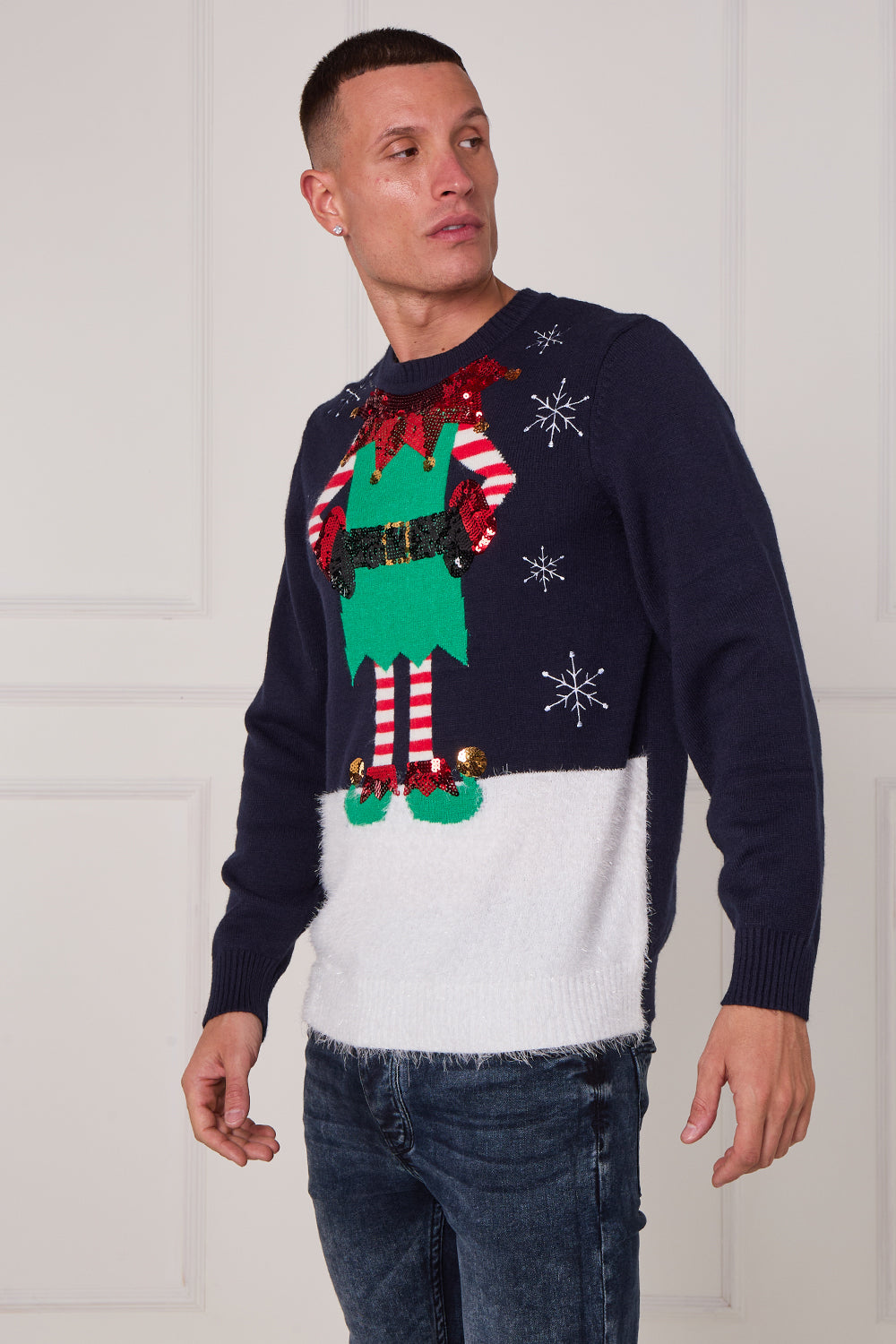 Man wearing a festive sweater with an elf design on a white background