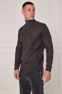 Man wearing a dark gray cable knit sweater with a zipper against a white background