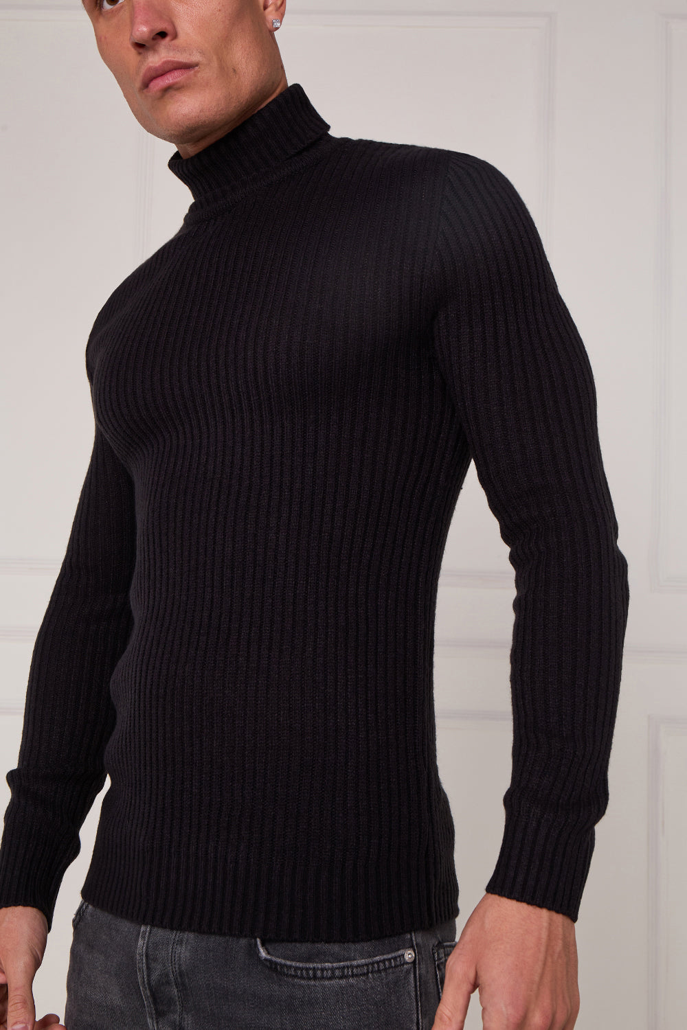 Person wearing a black turtleneck sweater against a white background