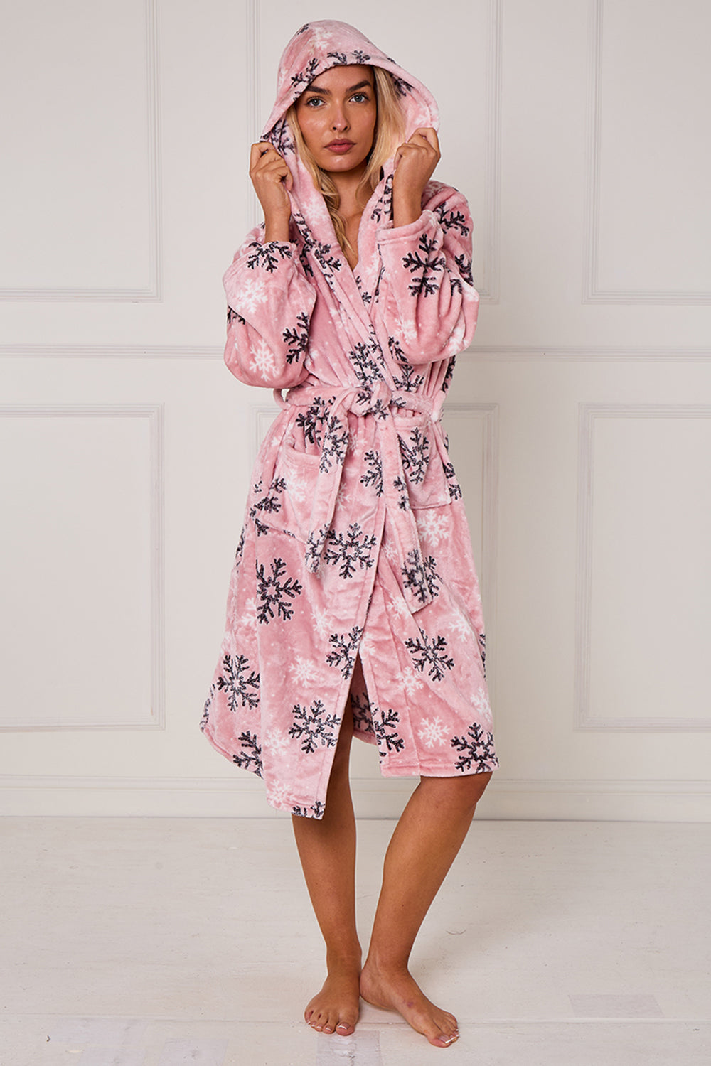 Woman wearing a pink floral robe against a white background