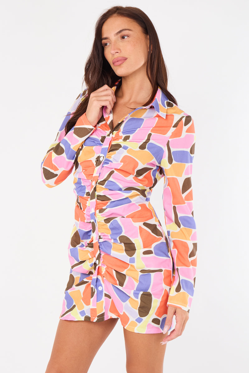 Woman wearing a colorful patterned shirt dress on a white background