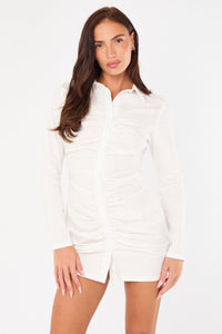 Woman wearing a white ruched shirt dress on a white background