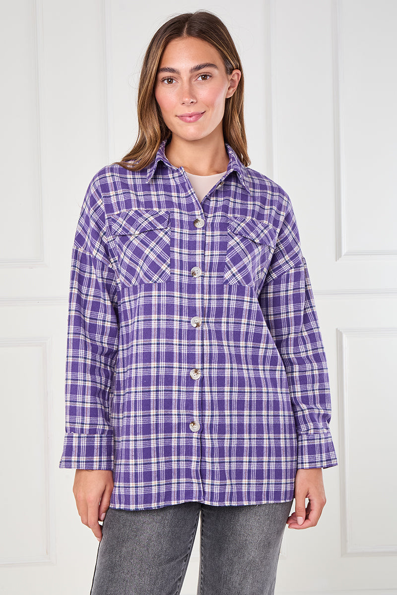 Woman wearing a purple plaid shirt against a white background