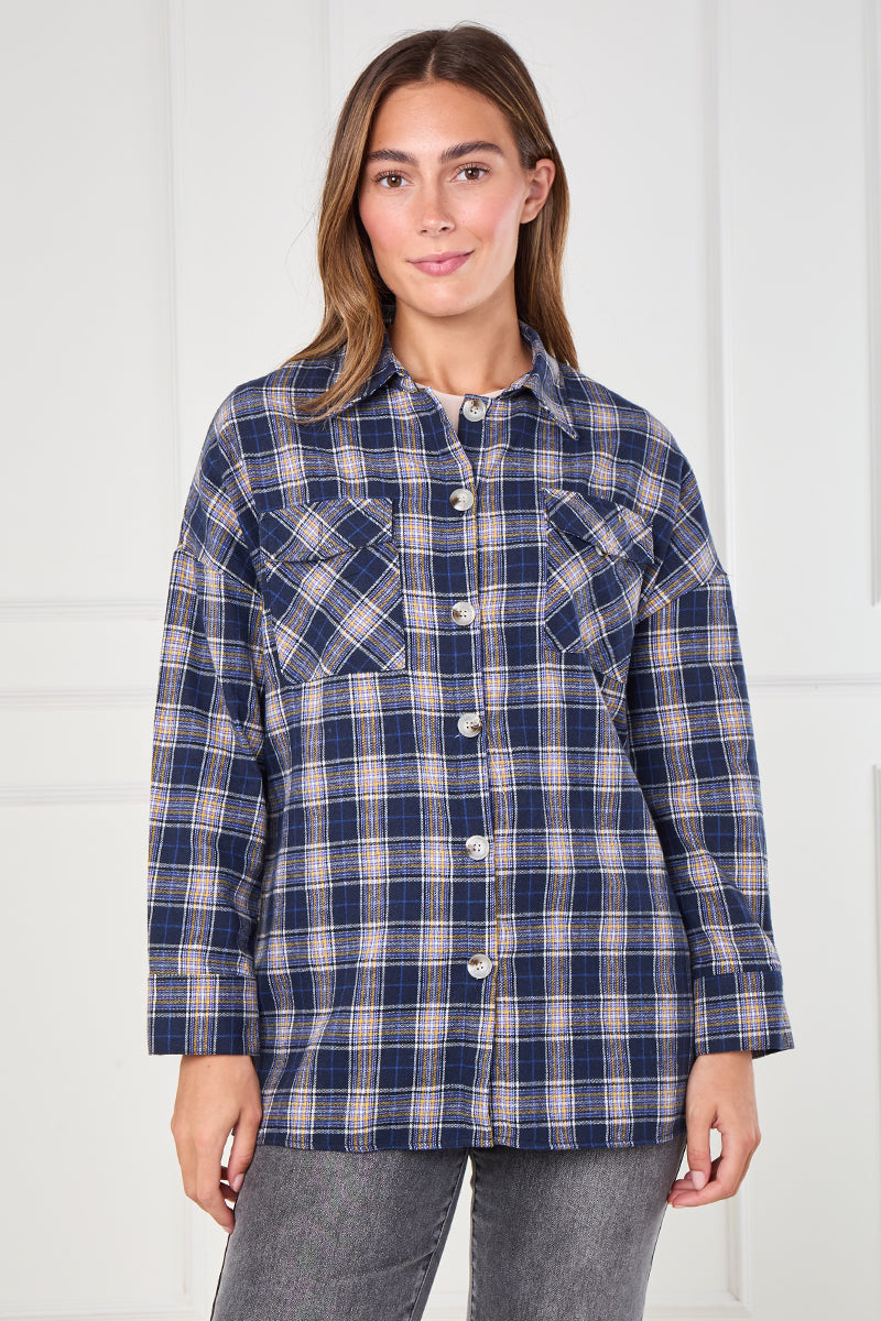 Woman wearing a blue plaid shirt against a white background