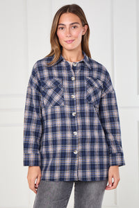 Woman wearing a blue plaid shirt against a white background