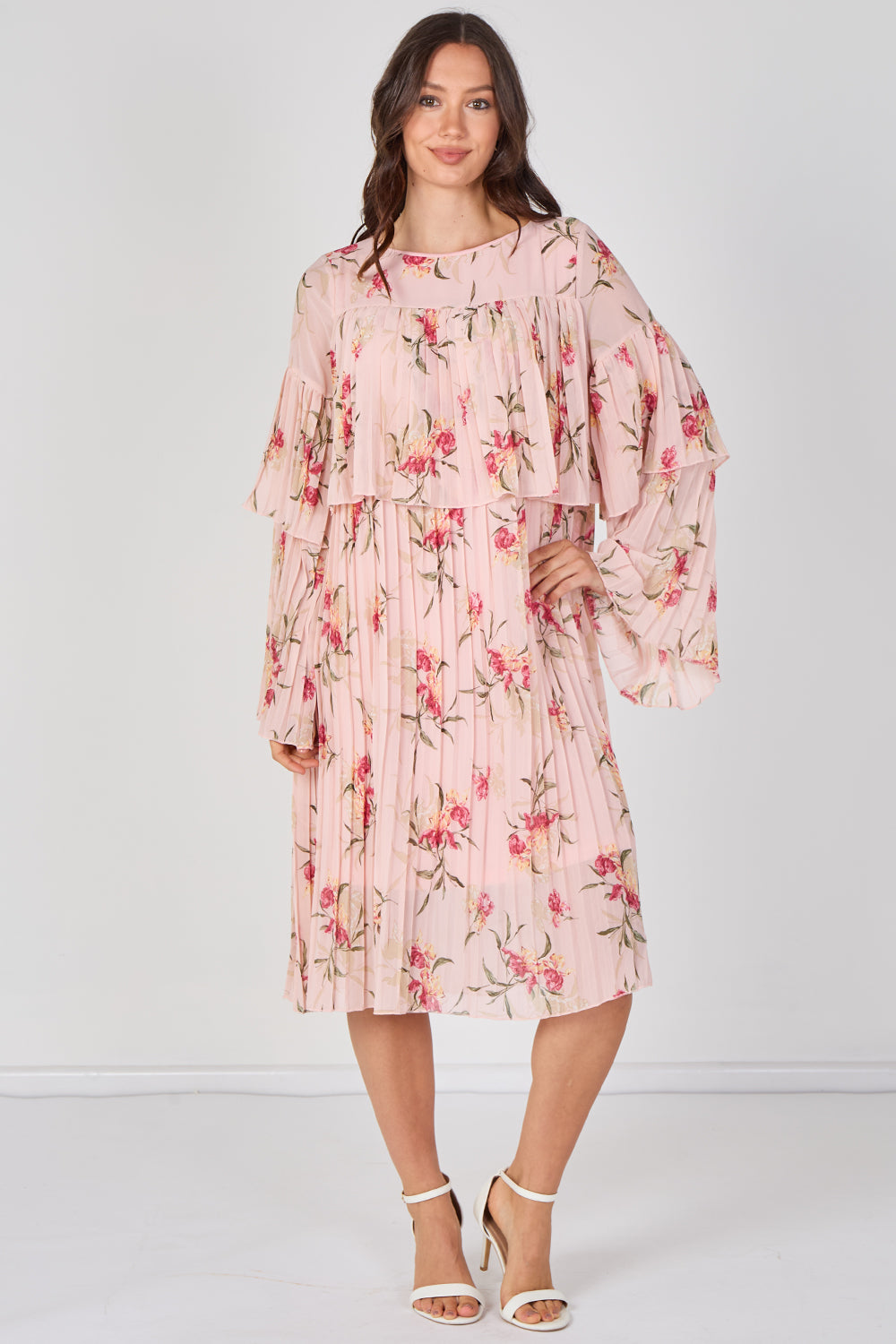 Woman wearing a pink floral dress against a white background
