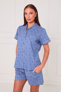 Woman wearing a blue pajama set with a white background