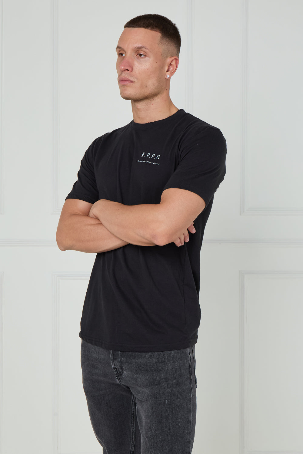 Man wearing a black t-shirt with a logo on a white background