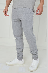 Person wearing gray jogger pants and white sneakers on a white background