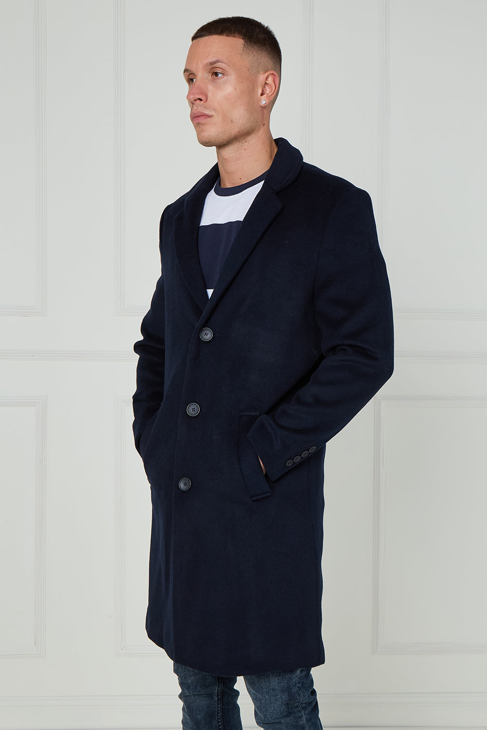 Man wearing a navy coat against a white background